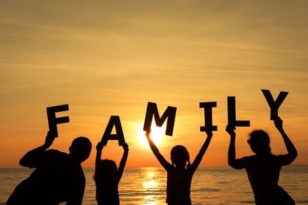 An illustrated family holding up colorful letters that spell the word "FAMILY."